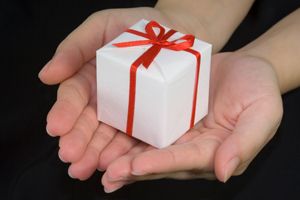 Cupped hands with gift box