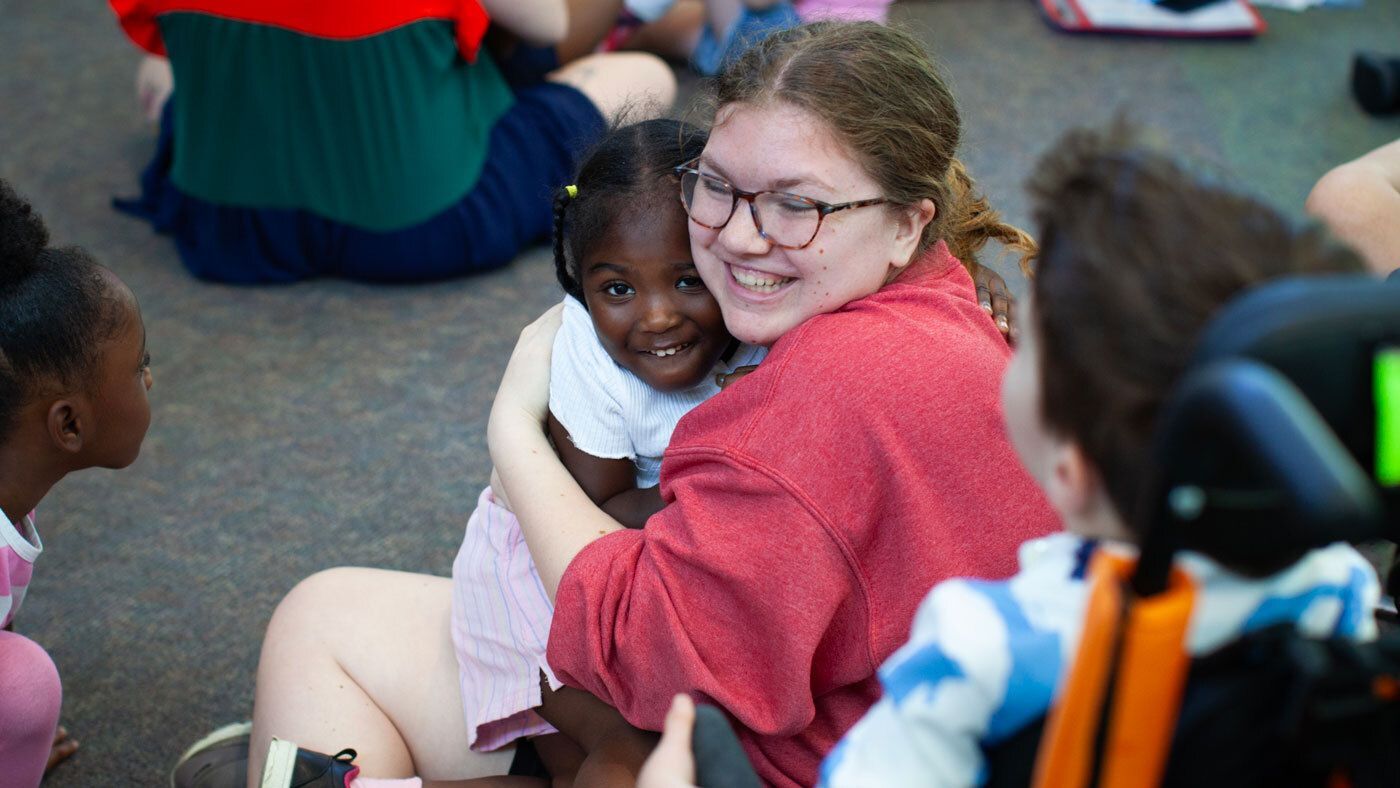 Big hugs between staff and kids at our Southwest location