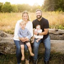 Brittany, her husband and 2 children sitting outdoors smiling at the camera