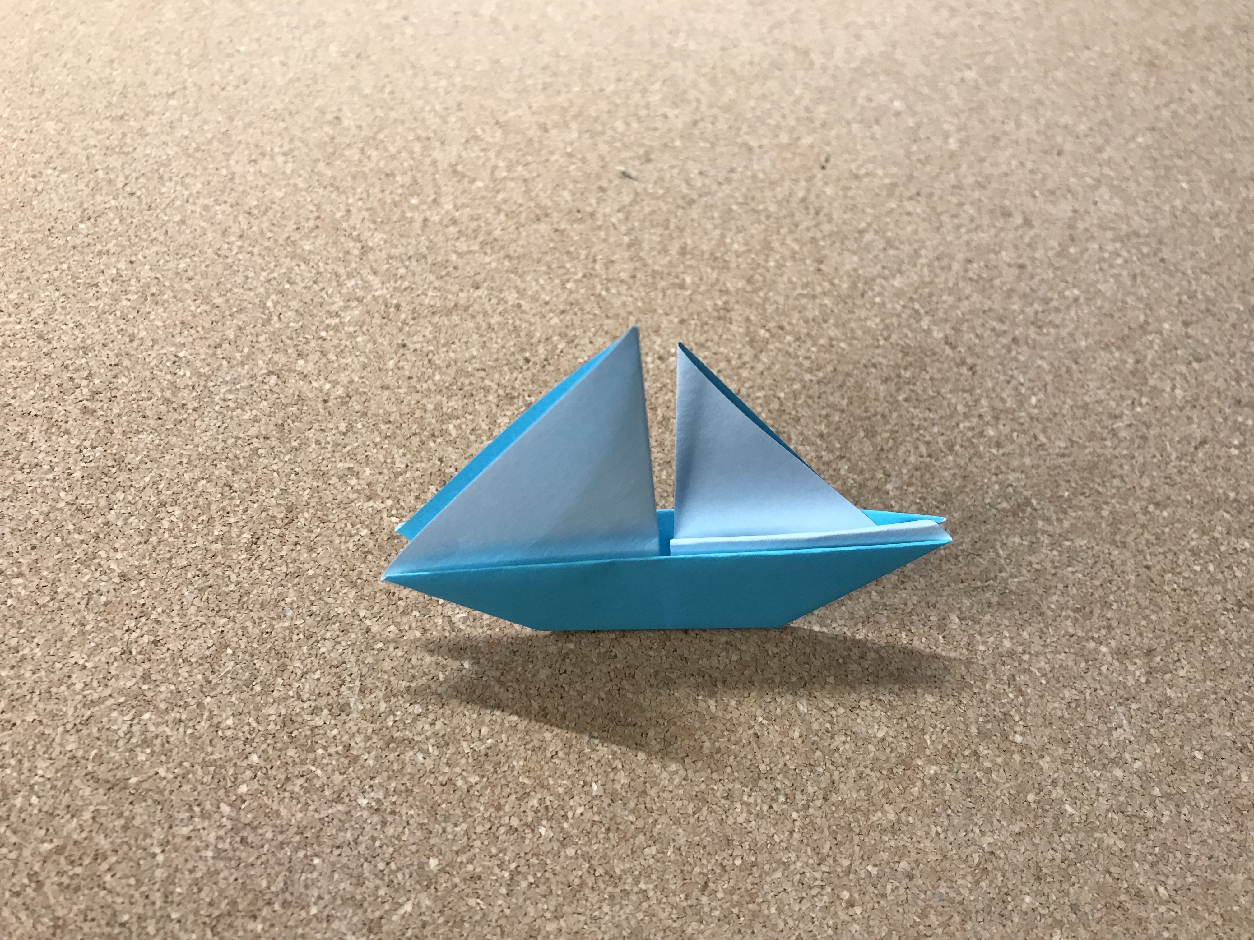 A small blue origami sailboat