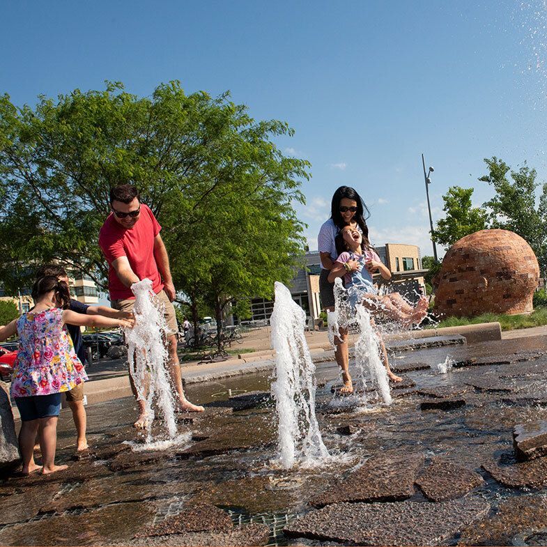 Children and parents playing in a splashpad.