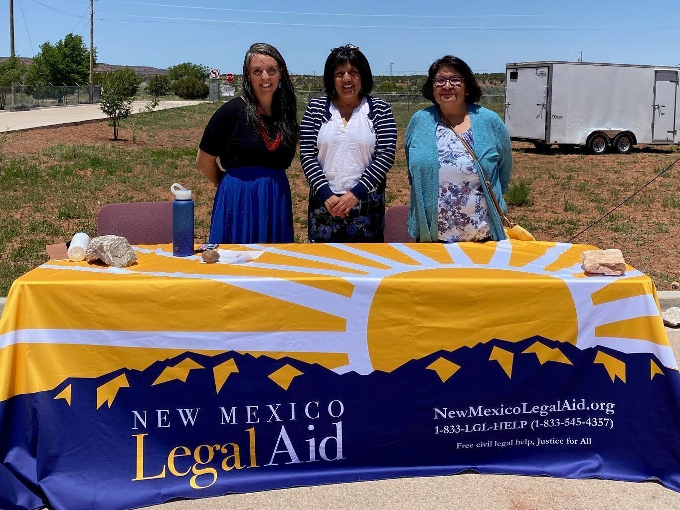 Native American Program Staff behind a table at an outreach event