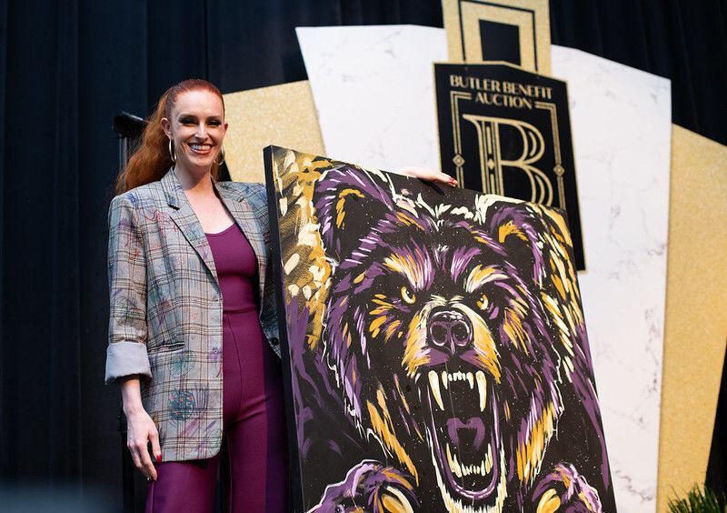 Annika Wooton pose with the Grizzly she painted for the live auction