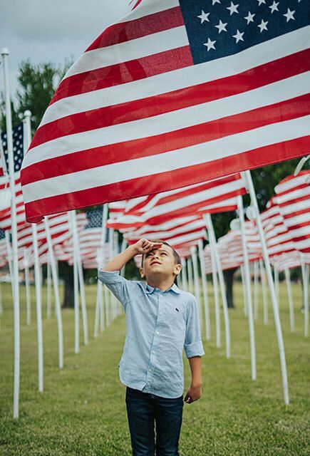 American flag with the sun shining in the background.