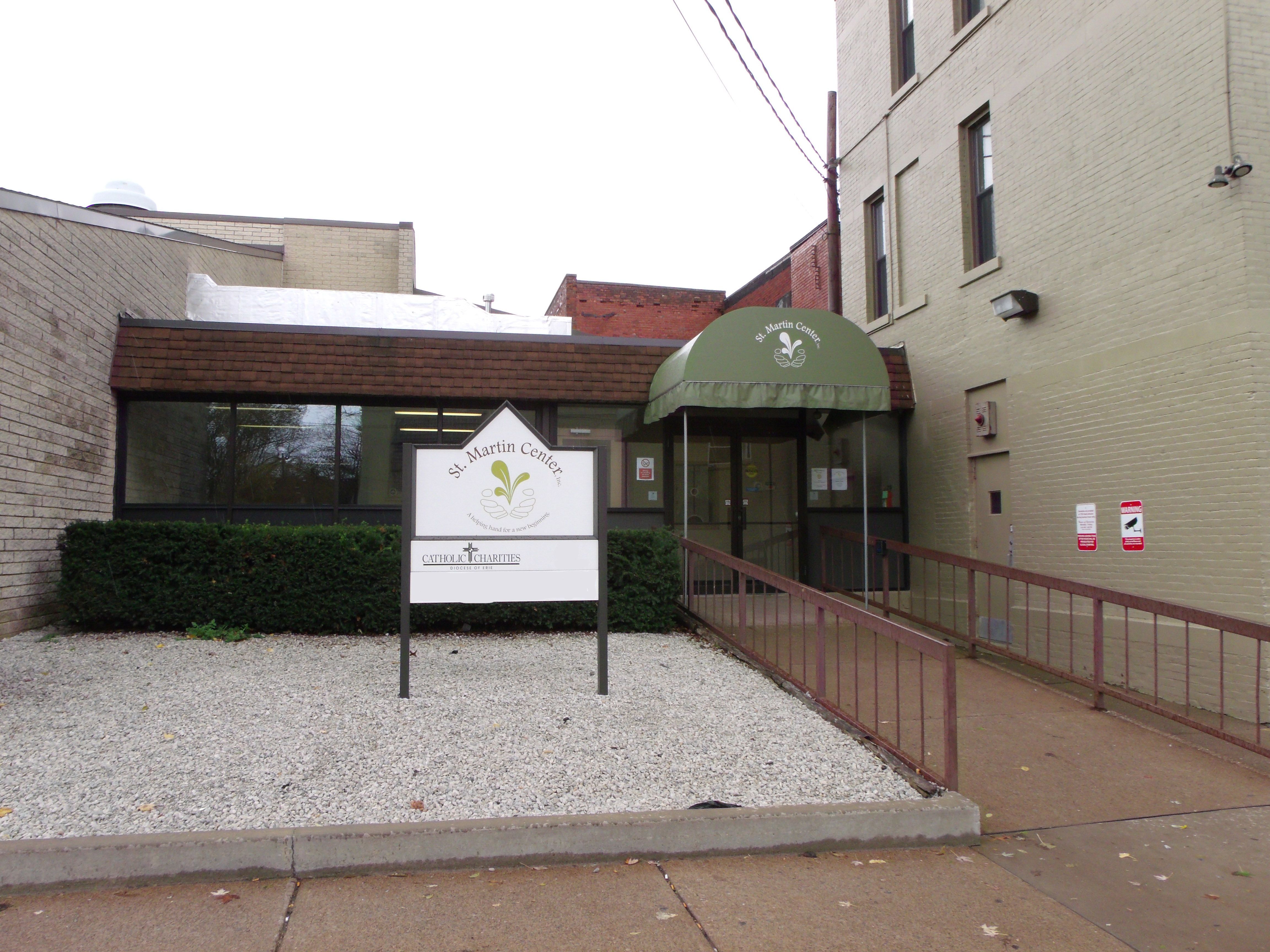 A view of the St. Martin Center building.  This faces a door with a ramp and an awning over top.  There is a sign that says "St. Martin Center"