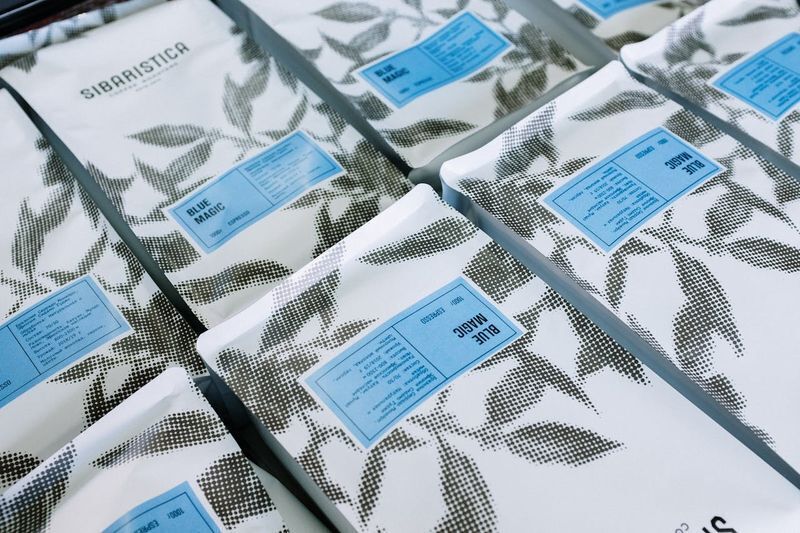 Printed coffee bags displaying a consistent blue label. Effective brand color management ensures these brand colors match perfectly every run.
