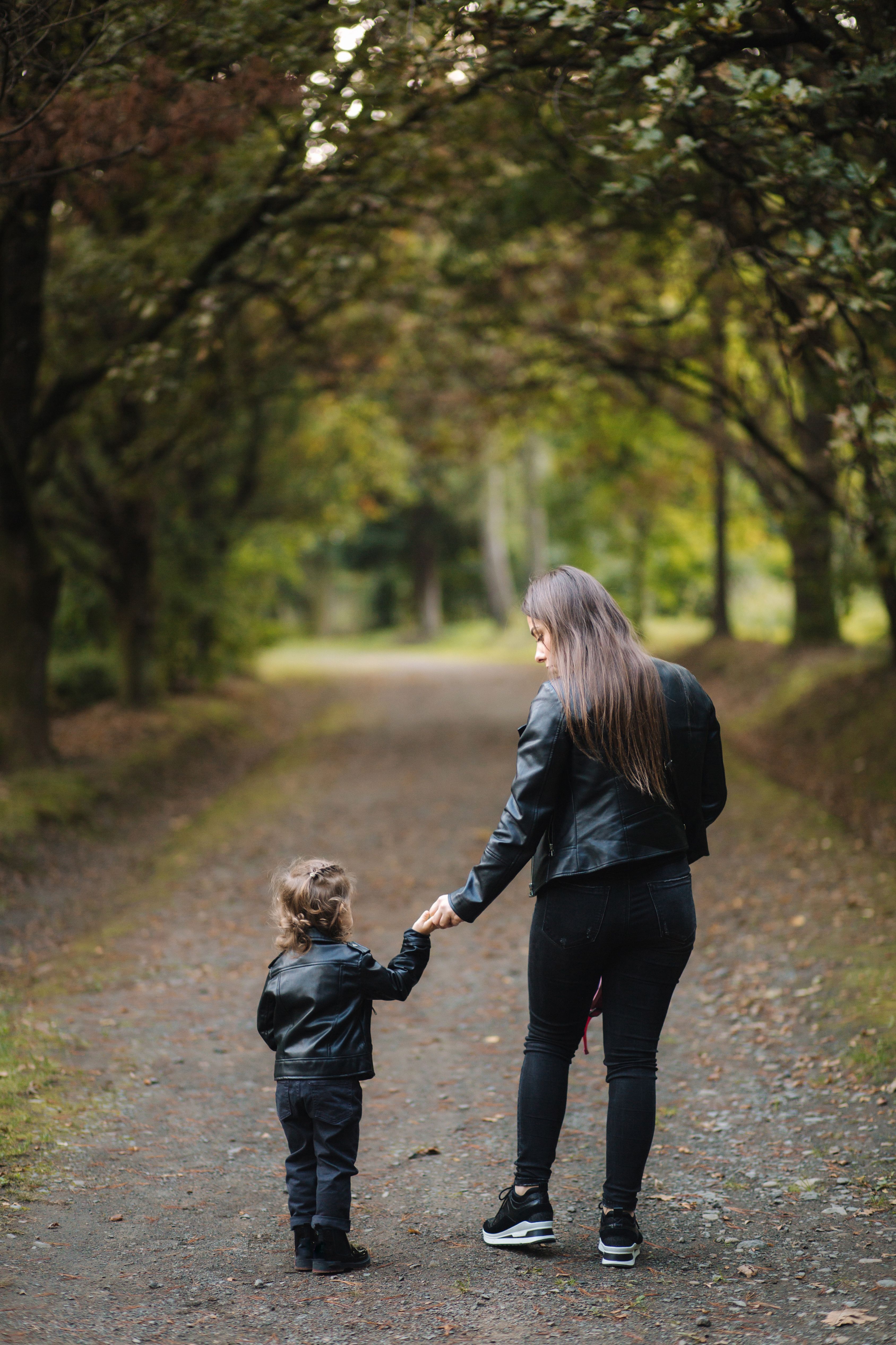 Little kid and their mom walking through the forest
