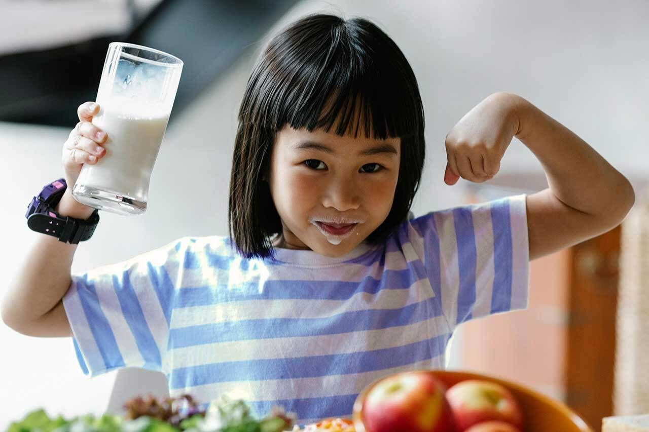 Girl flexing with glass of milk