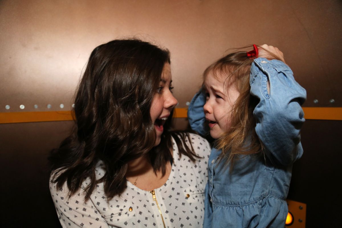 Two girls in a tornado simulator in the Smoky Hill Museum exhibit The Curiosity Shop.