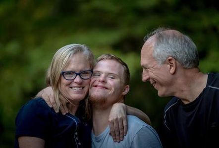 two parents and one son smiling