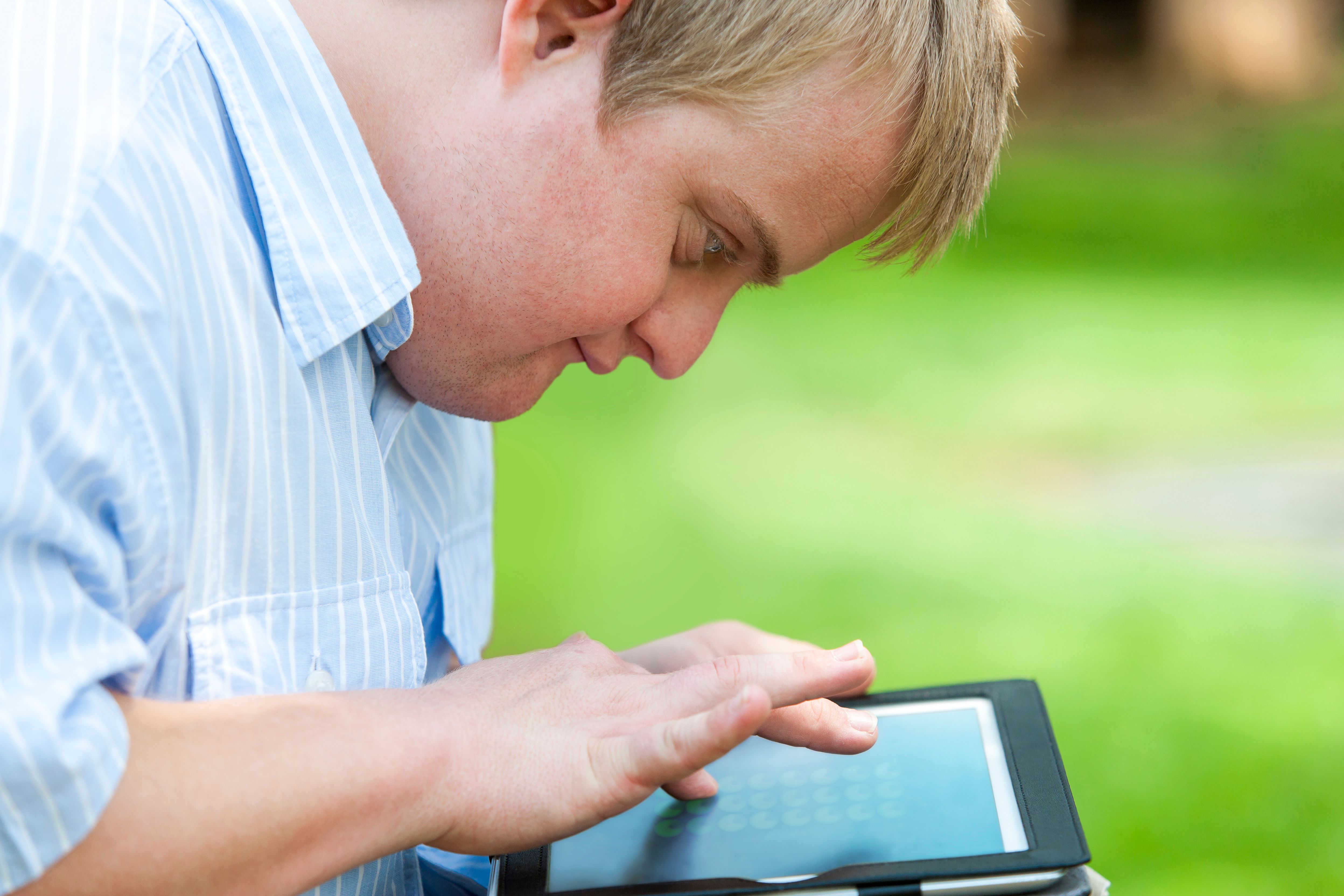 Young man taps a tablet screen