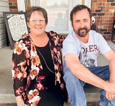 Photo of Rhonda and Luke sitting together on a front porch.