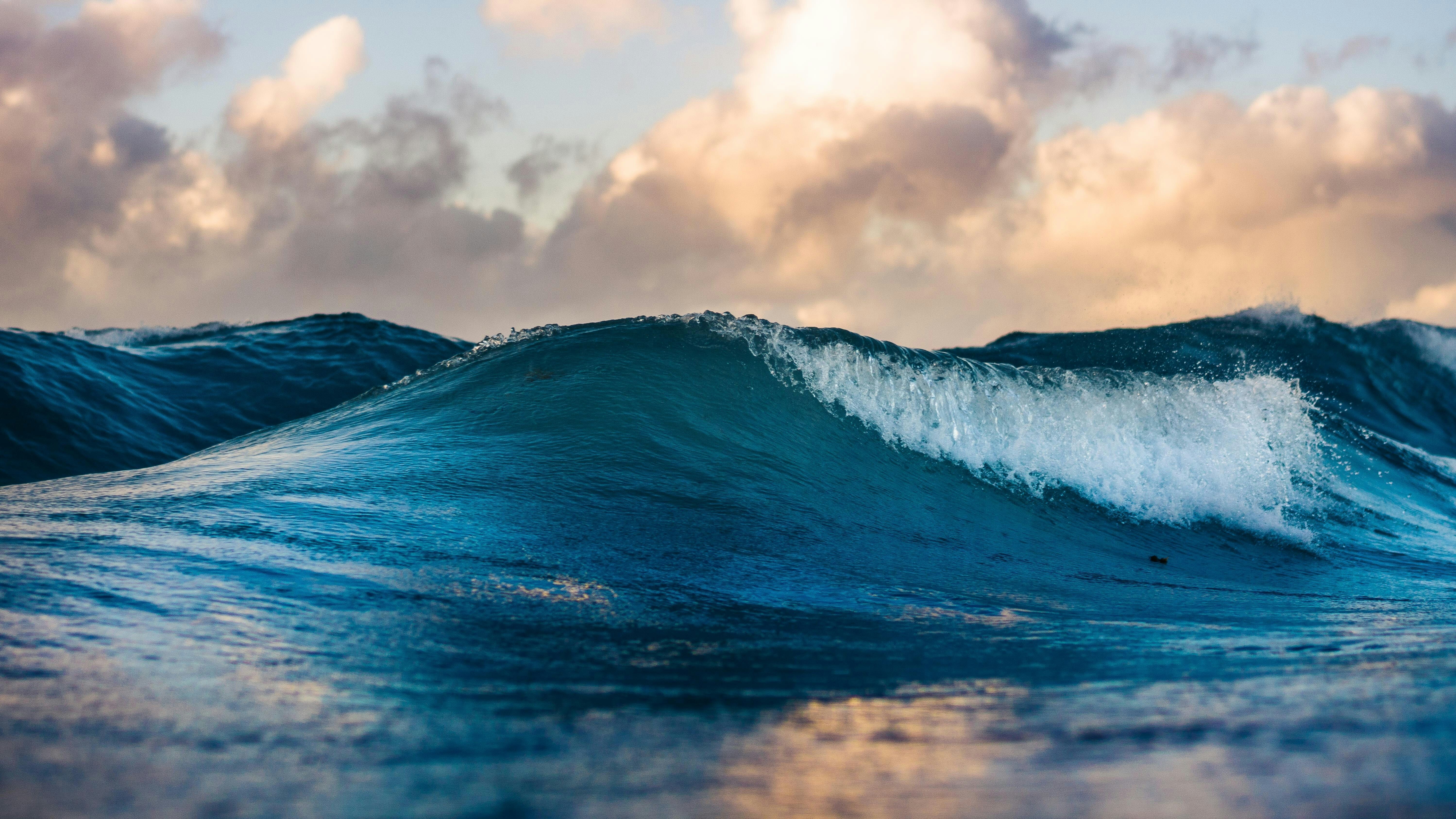 Ocean waves below cloudy sky