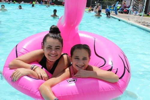 Campers smile on a float in the pool.
