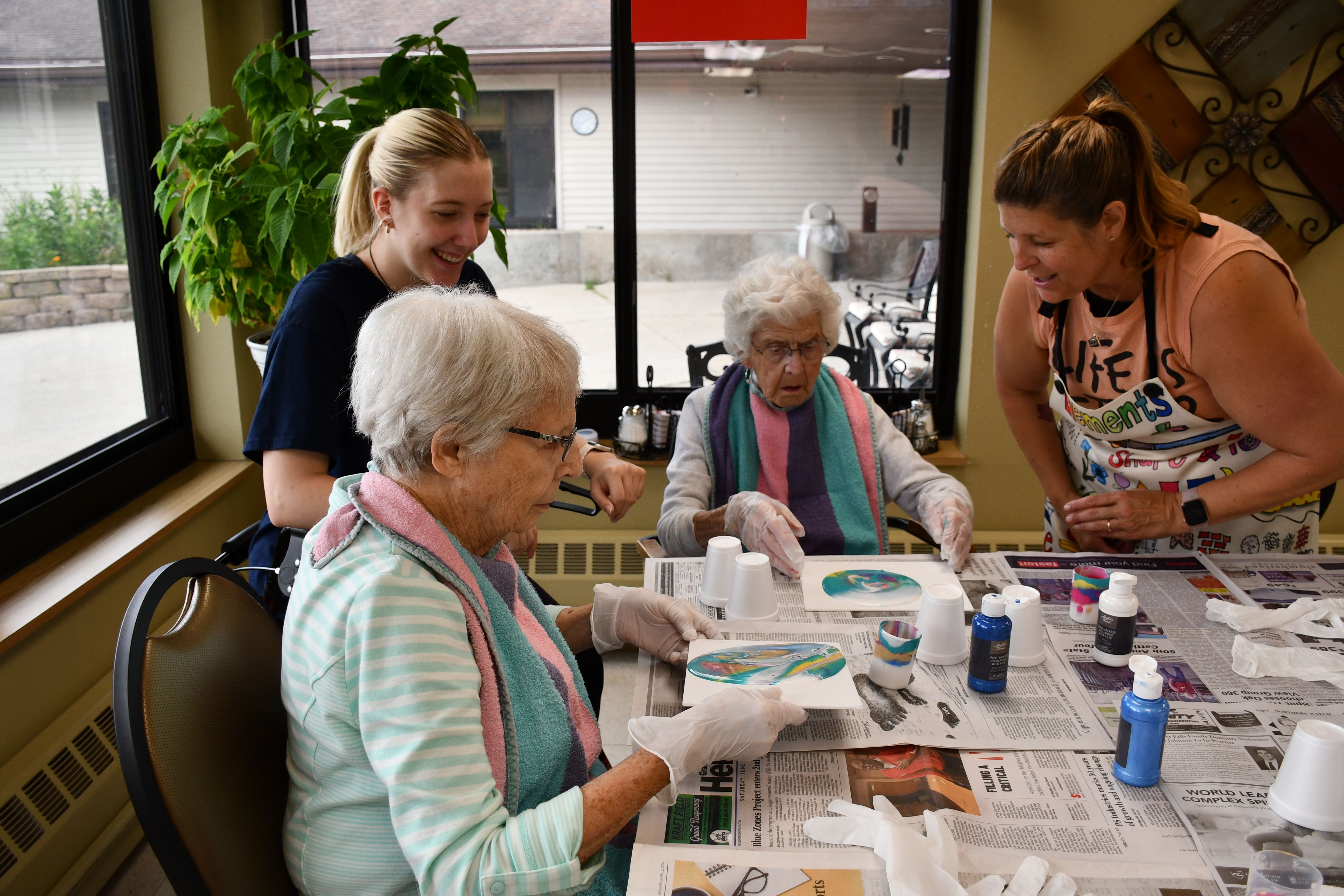 Nursing home residents relish painting with Sandie Doll-Nelson.