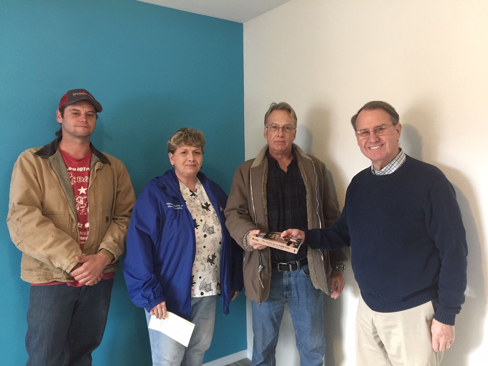 House Blessing for House #27. Photo Left-Right: Russell Martin, Kathy Vanschuyver, homeowner Ben Vanschuyver, Rev. George Warren