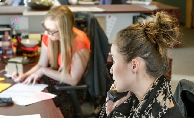 Two Women at Desk on Phone