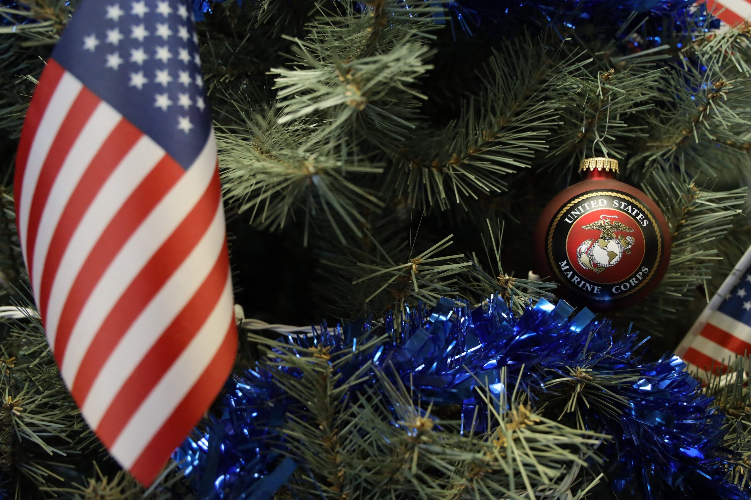 A white Isuzu box truck parked in a lot, branded with the CARE Community Center logo and contact information. The logo features concentric circles with a heart in the center, in blue, pink, and red. 