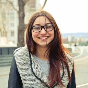 teenage girl with long hair and glasses smiles