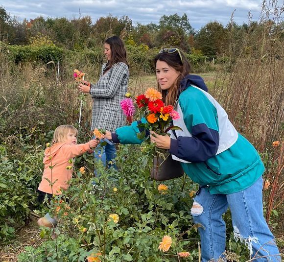 A mother and young daugher pick flowers in a field at Snipes Farm