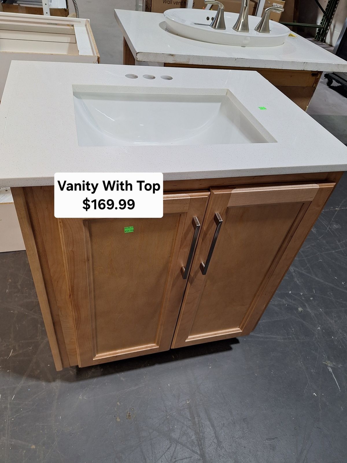 Modern bathroom vanity with white sink top and wood cabinet base available at Habitat ReStore Zephyrhills – $169.99