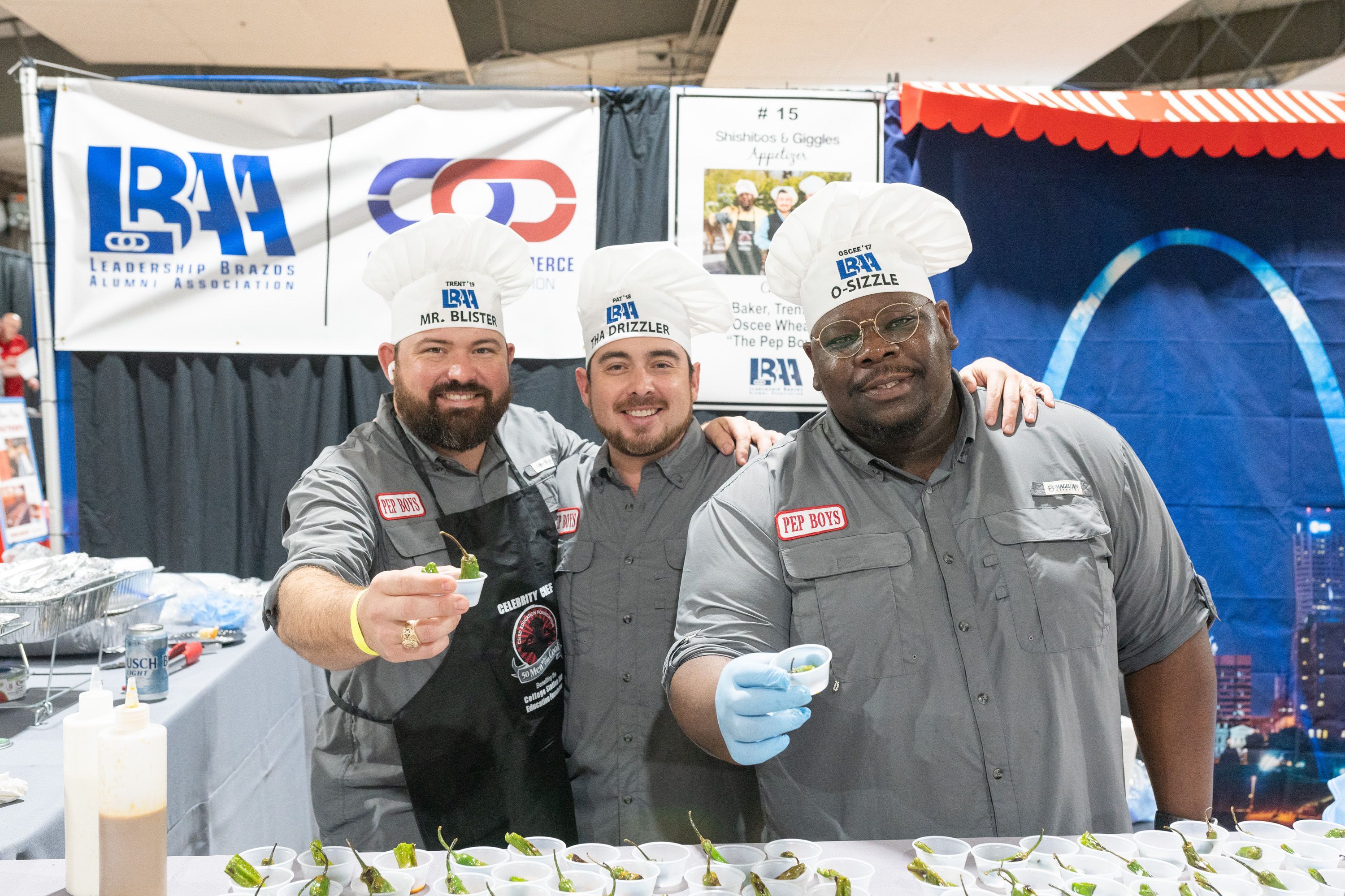 Three men serving food from a booth