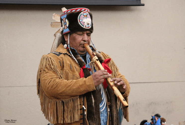 Dan Nanamkin, an Indigenous artist, playing a flute at a Red Barn Event.