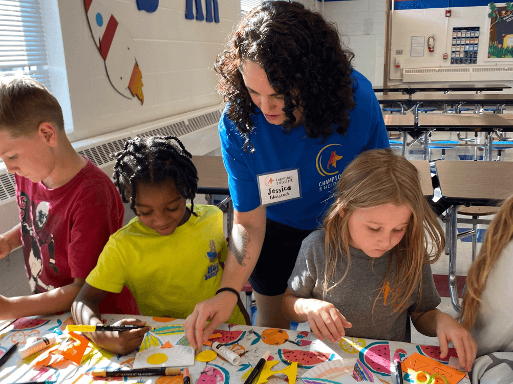 Volunteer assisting students with a colorful art project