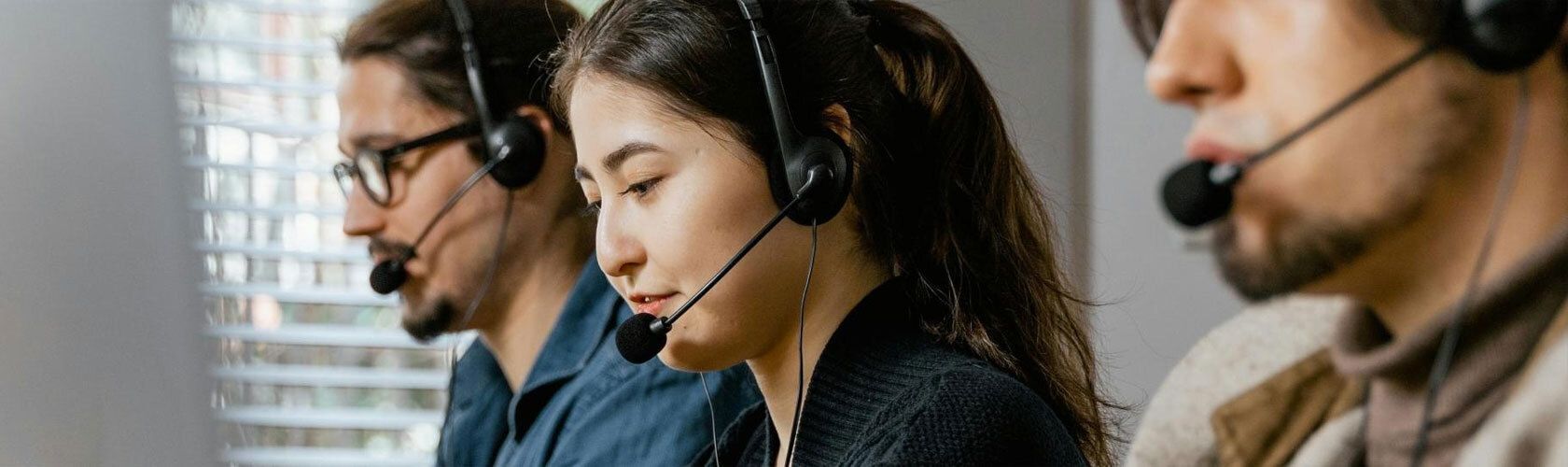 Three people with headsets on answering calls