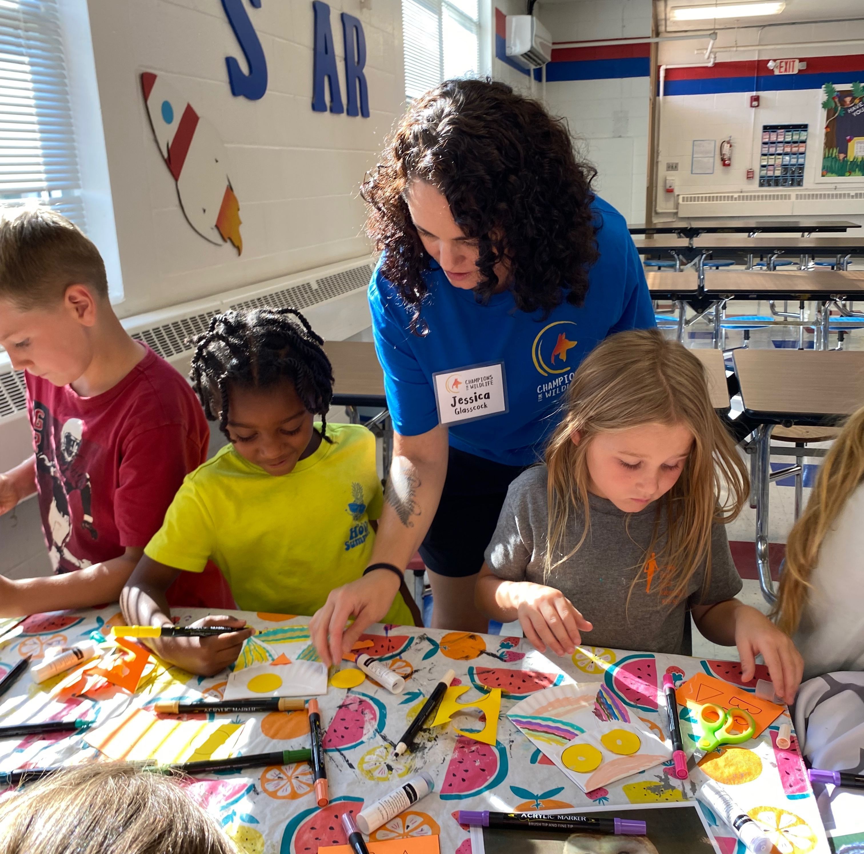 Volunteer assisting students with a colorful art project