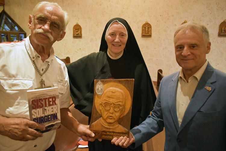 Deacon Ted Jorbowy, left, and Jerzy Bogdziewicz hold an image of St. Maximilian Kolbe signed by Sister Deirdre Byrne