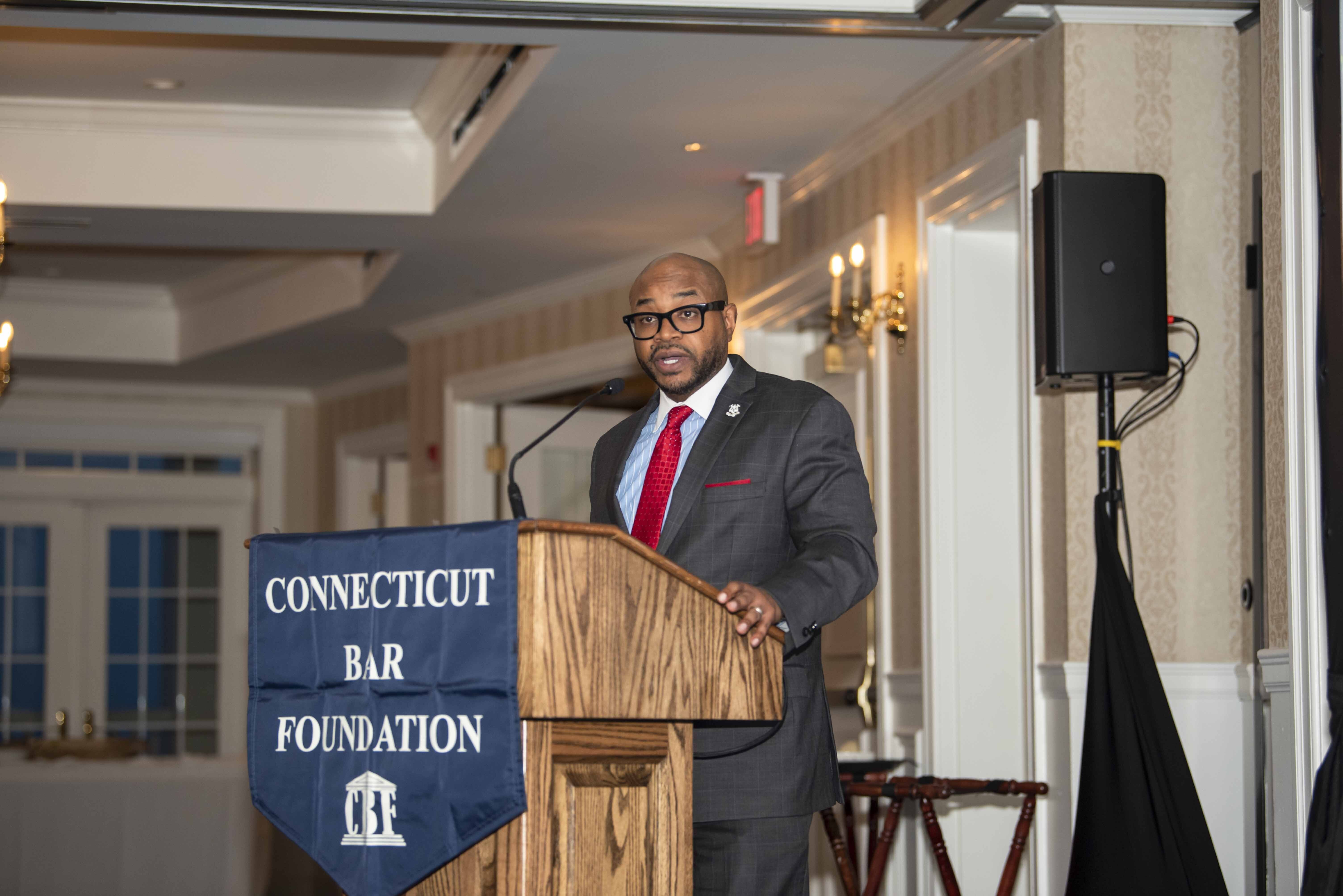 Chief Justice Raheem Mullins delivering keynote address at podium.