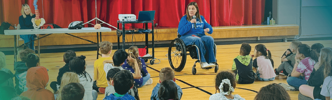 woman  in wheelchair talking to students