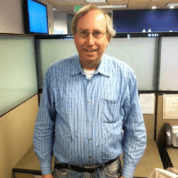 Gary standing at his office facing the camera and smiling. 