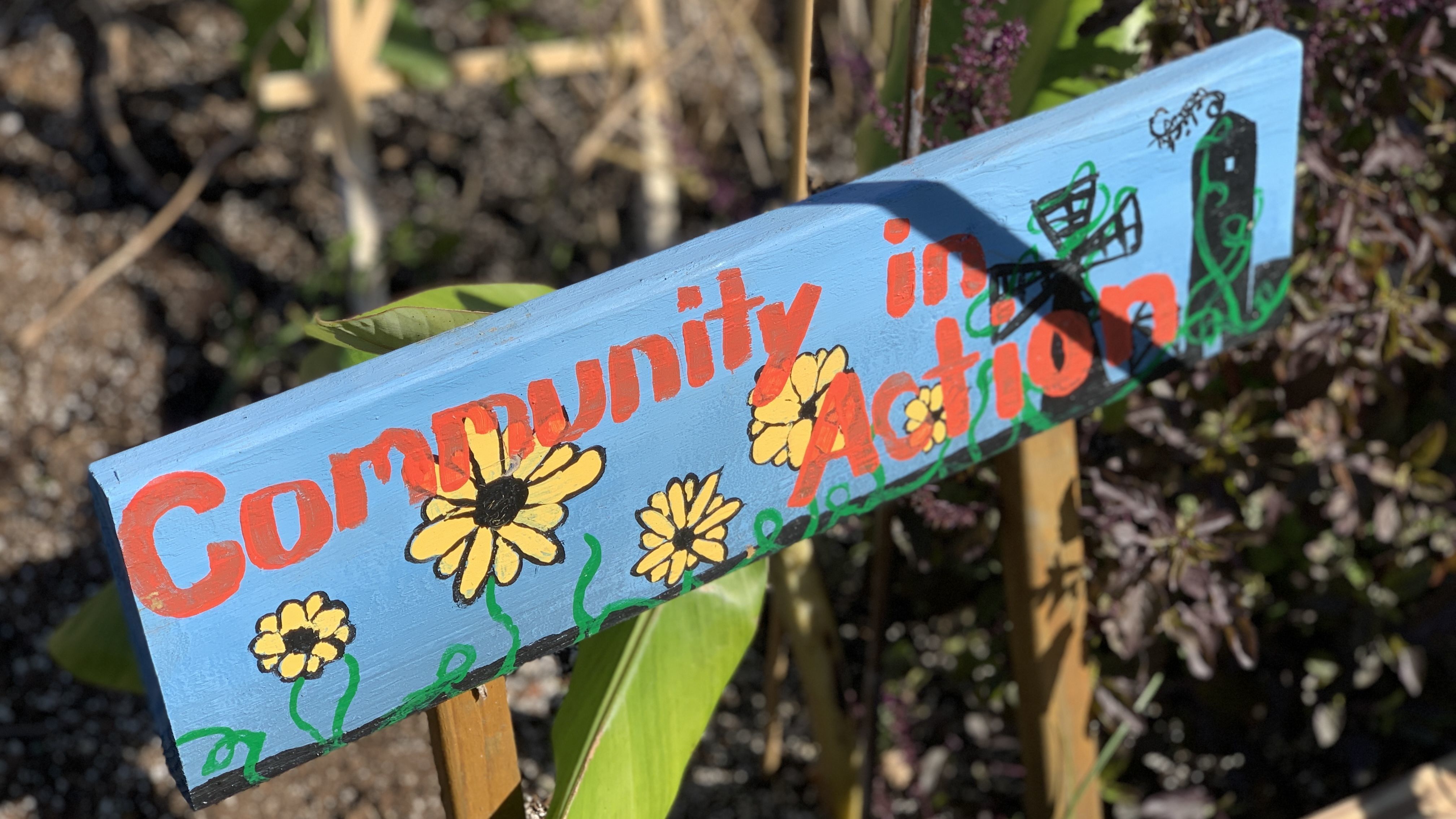 Picture of a hand-painted sign saying "Community in Action"