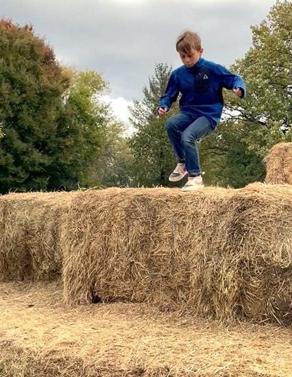 A boy jumps down the Hay Pyramid at Snipes Farm Fall Festival