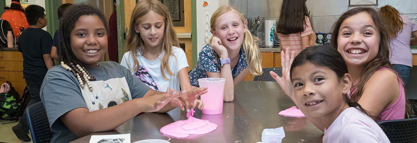 Children playing with slime at a table.