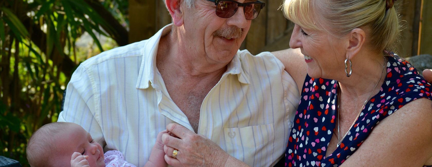 Grandparents holding their grandchild.