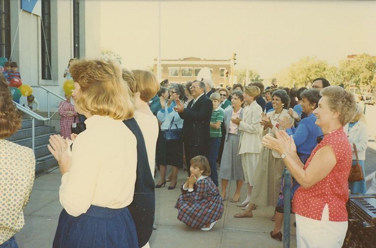 Crowd of people standing and clapping in front of the Museum 