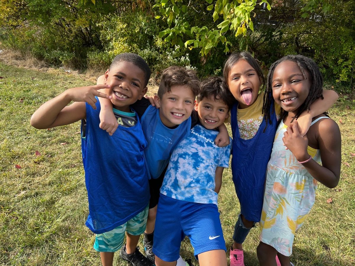 Children, arm in arm, laughing in the sunshine