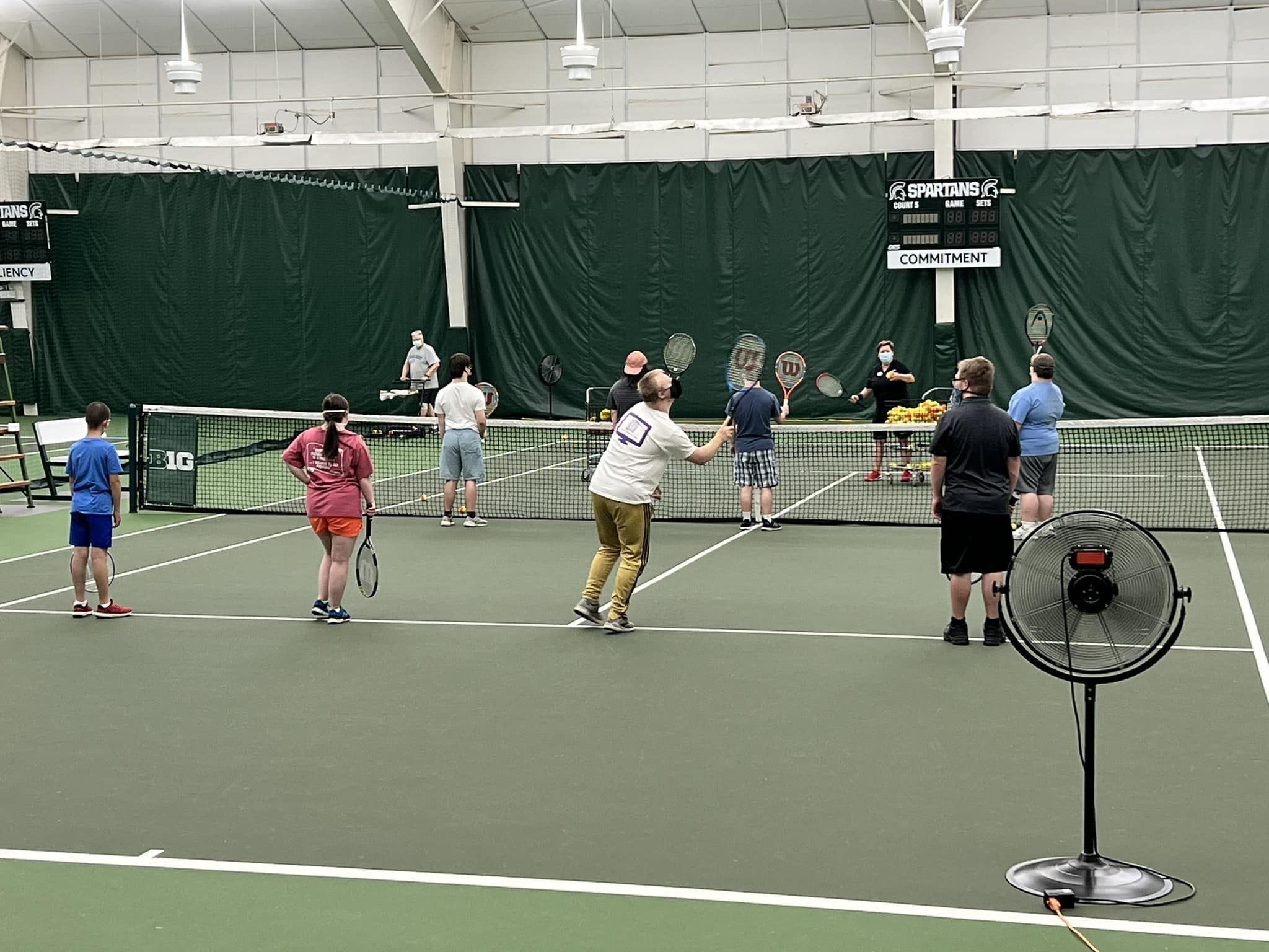 A group of tennis players with Down syndrome participating in class.