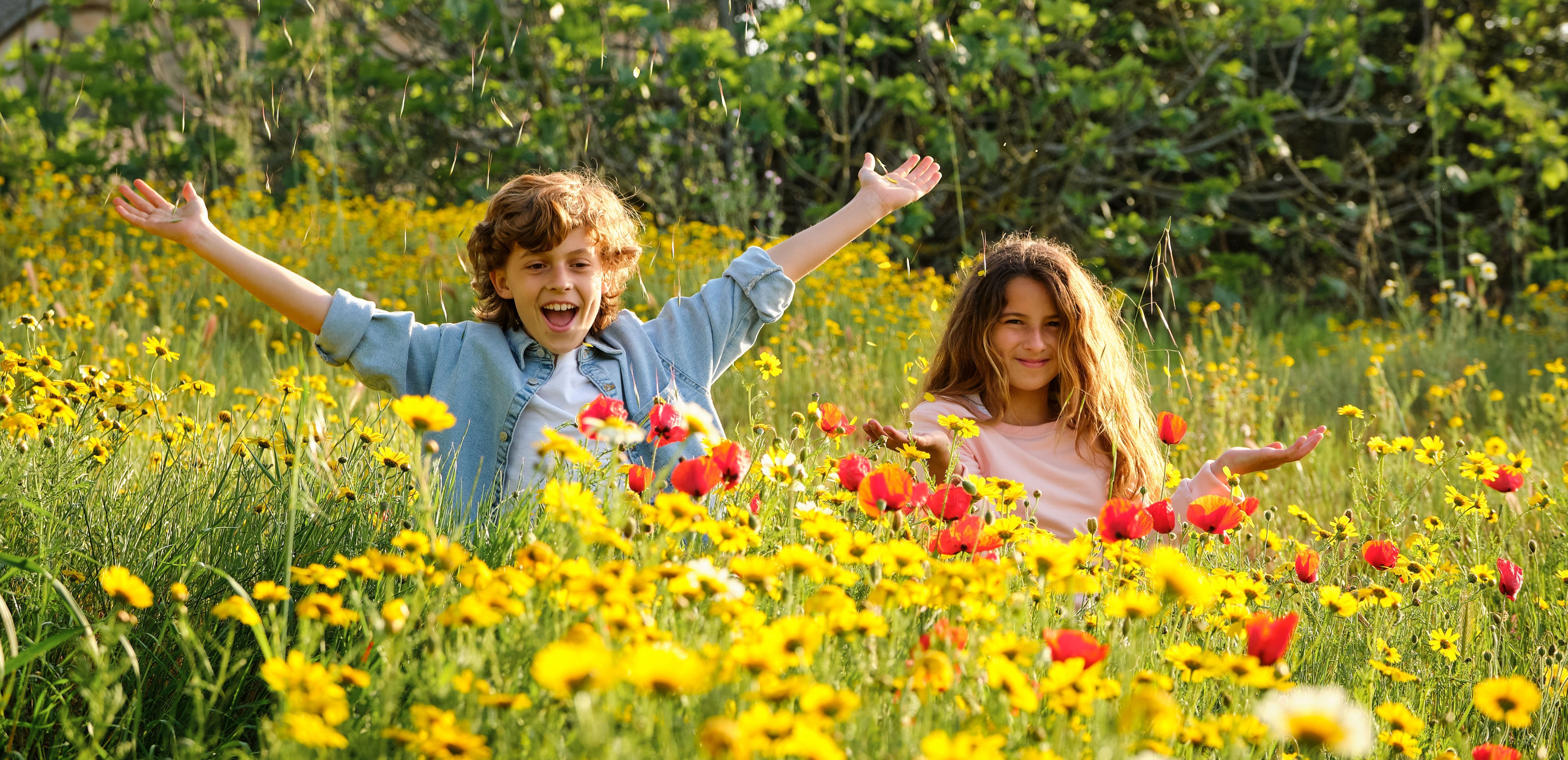 An image of a boy and a girl in a field of flowers.