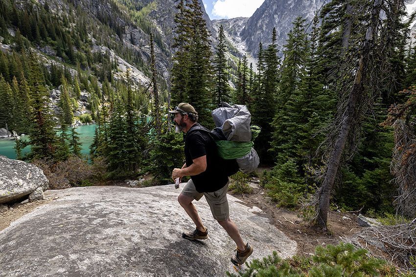 Mat Lyons, executive director of TREAD, a nonprofit advocating sustainable outdoor recreation, tears down an abandoned campsite at Colchuck Lake on Thursday. (Nick Wagner / The Seattle Times)