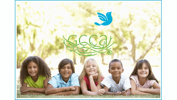 five smiling children of diverse races and genders lying in the grass under the Georgia Center for Child Advocacy logo