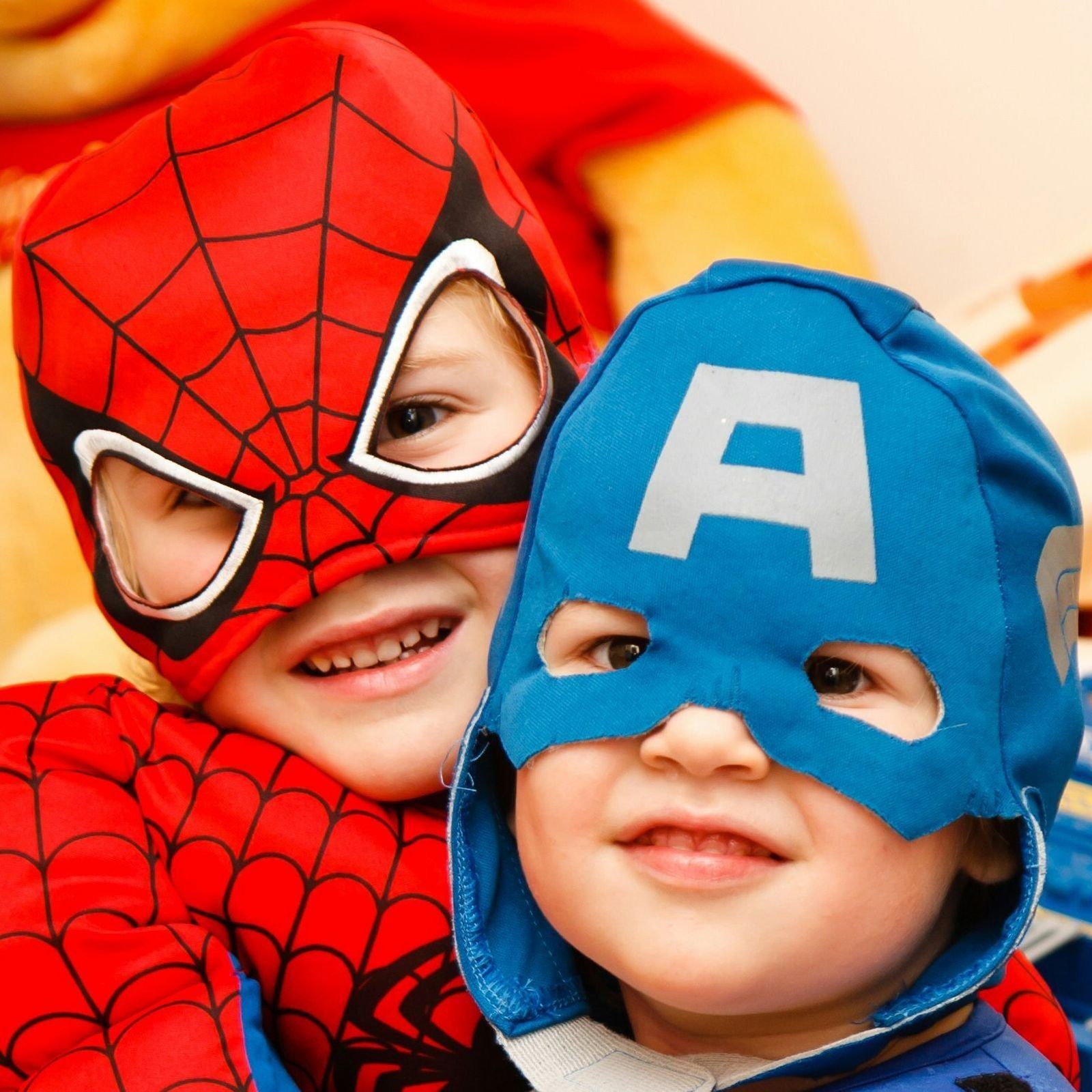 Two children wearing superhero masks