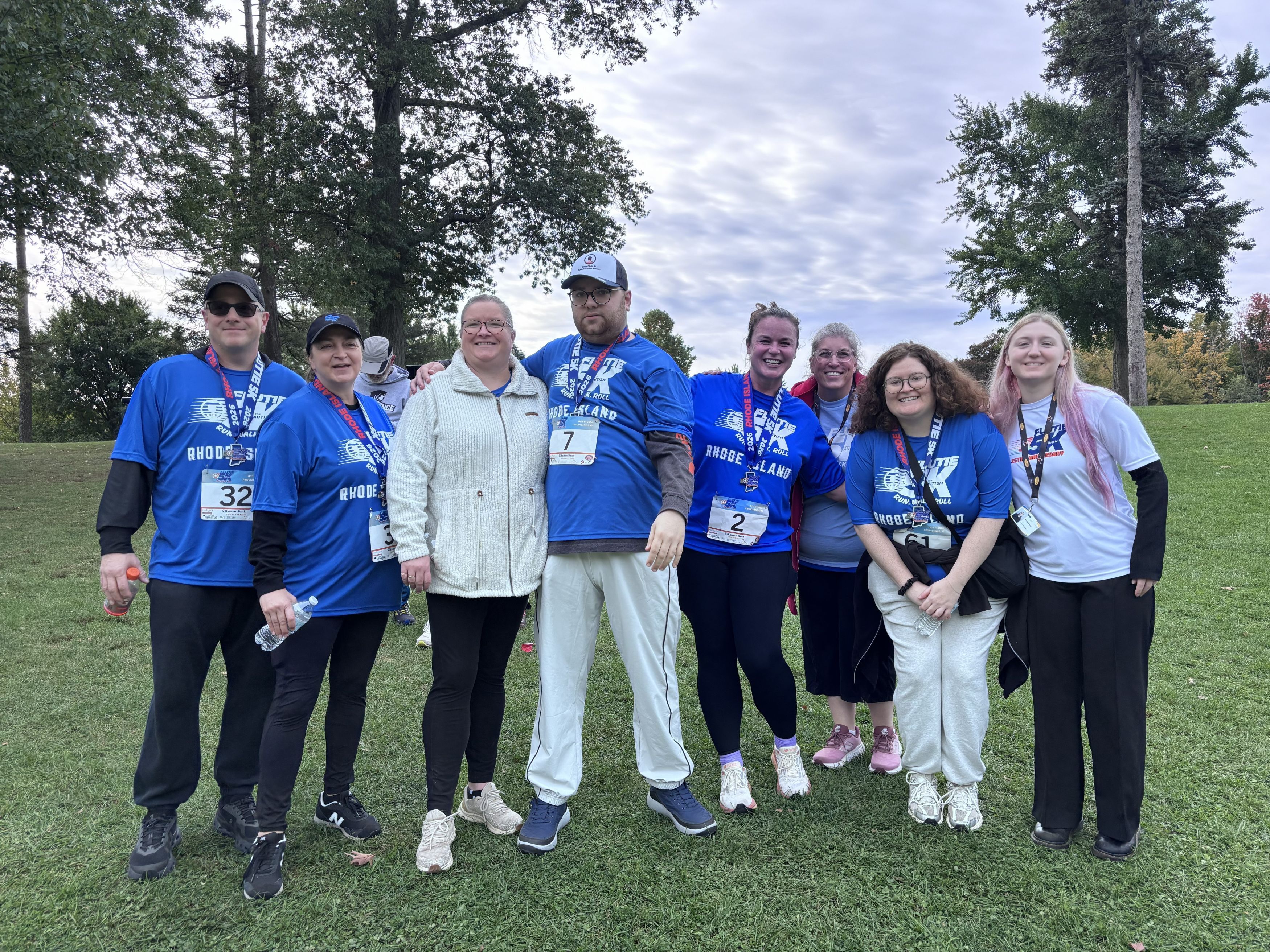 Group photo of individuals in blue shirts and white shirts from the Flutie 5K