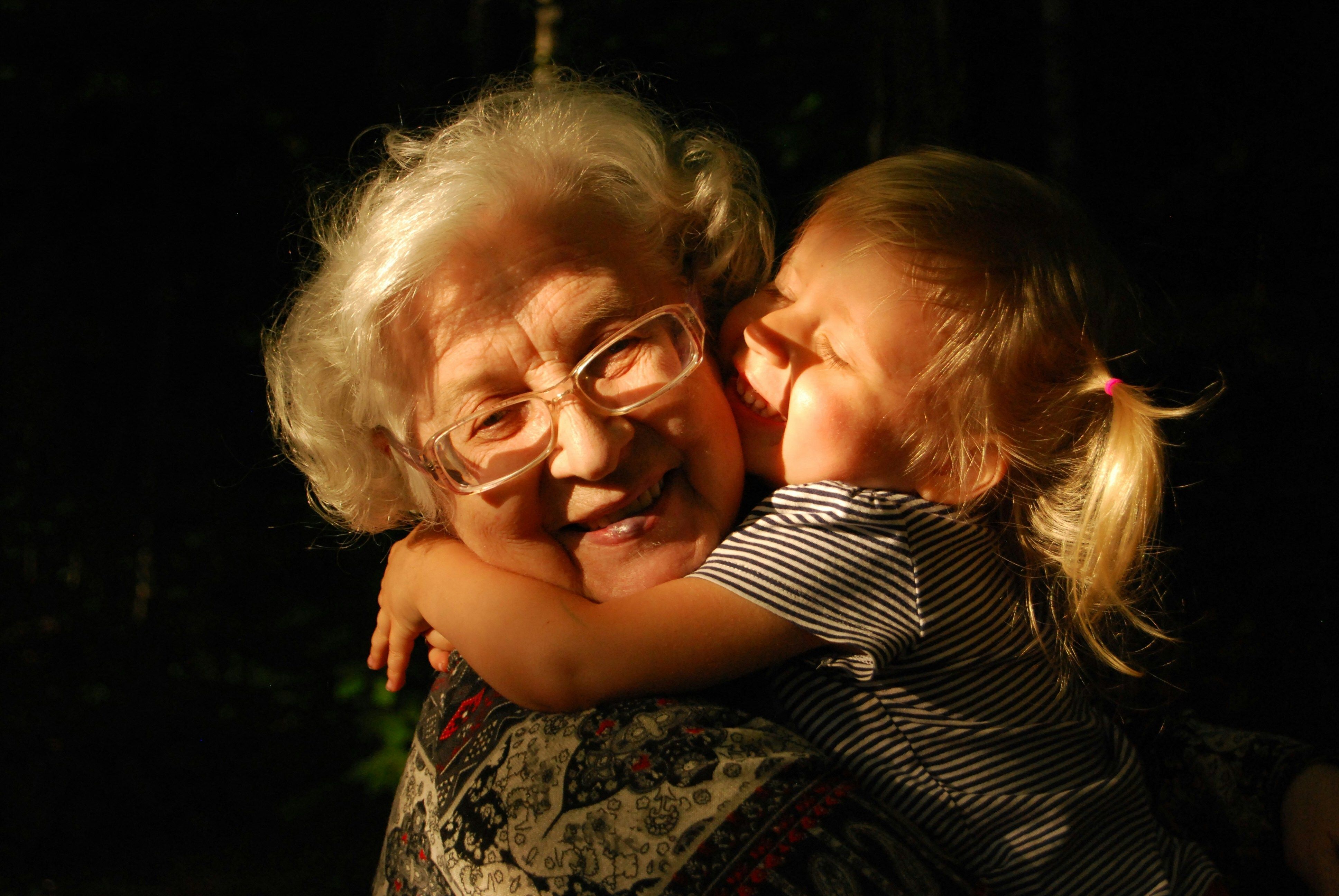 Child embracing grandmother in a warm hug, symbolizing lasting love and legacy.
