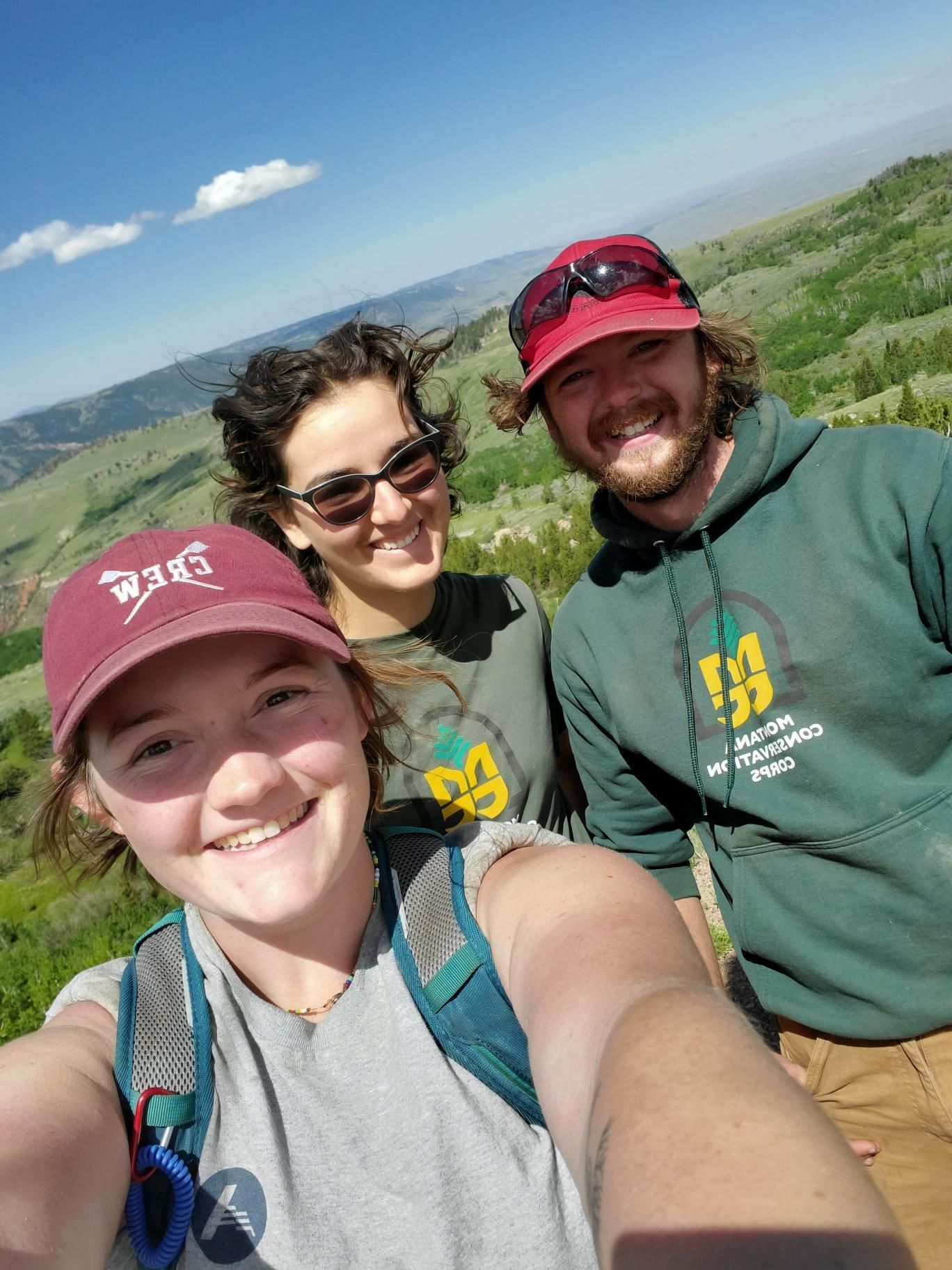 Three crew members take a selfie, smiling.