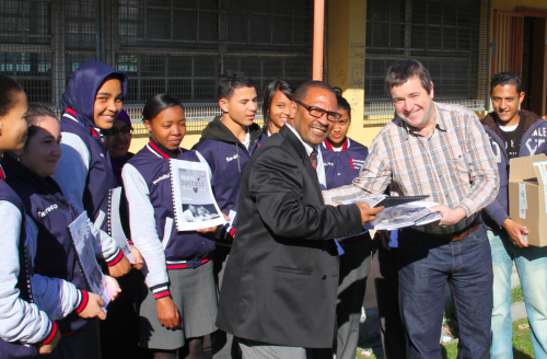 Rob Brickhill and Dean Mostert from Minuteman Press handing over the books to Mr Peters (acting principal) and some of the matrics from Silverstream Secondary School. 
