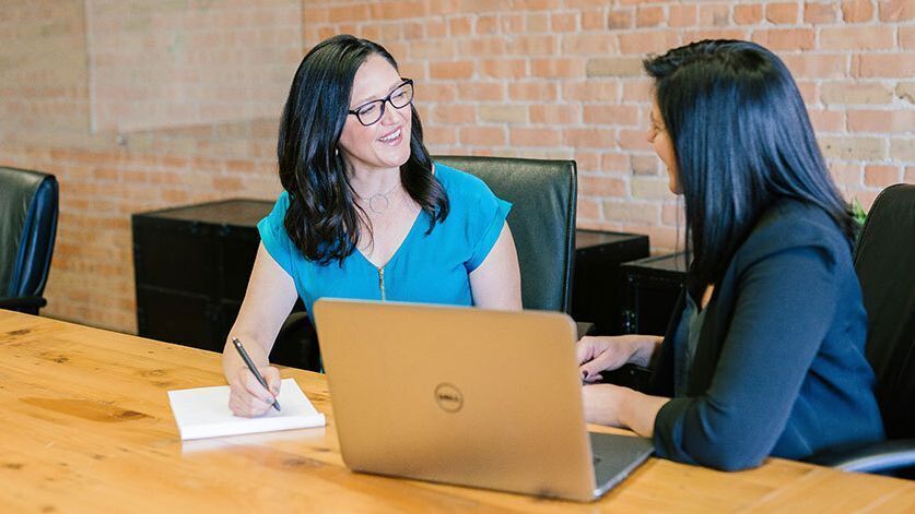 Two women look at a tablet